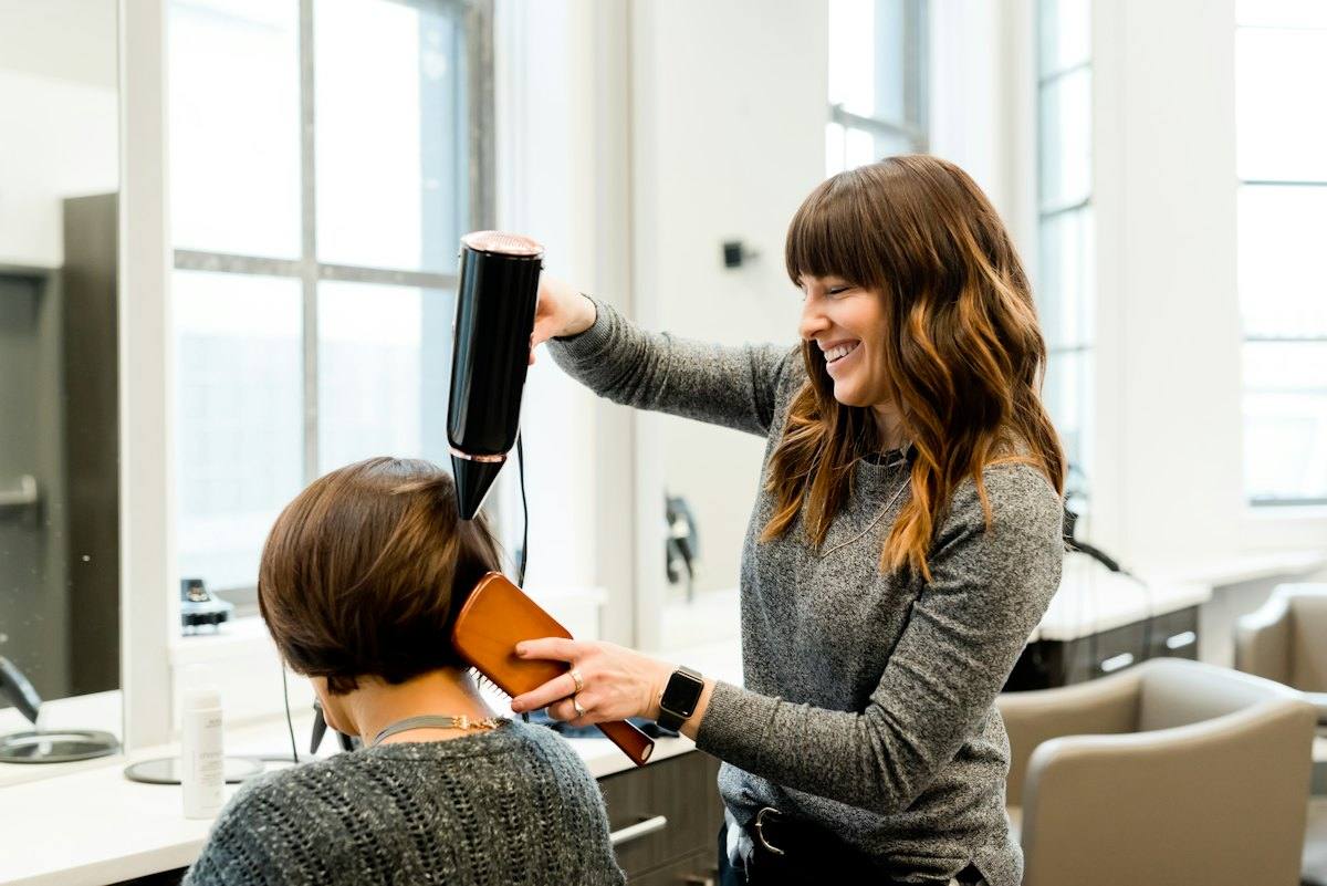 A stylist blow-drying a client